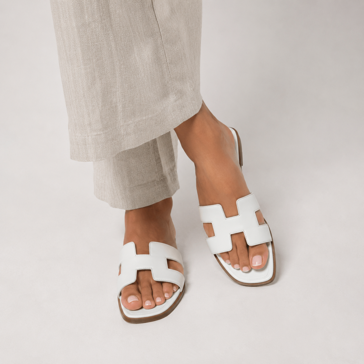 Mules plates femme en cuir à bride en H